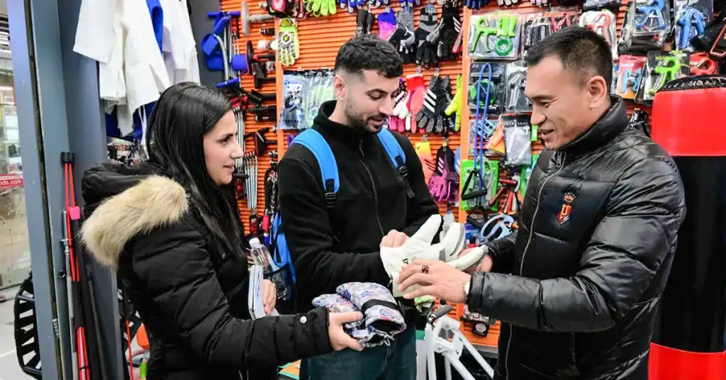 Buyers considering Switching Yiwu Sourcing Agents inspect sports gloves at Yiwu Market.