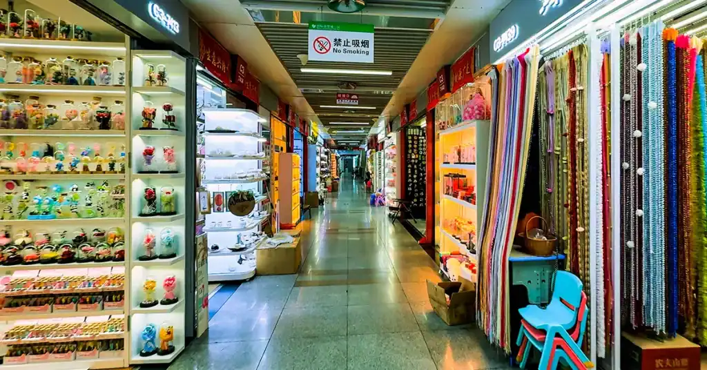 What Yiwu market doesn’t sell starts here: a corridor of small-commodity booths with glass-dome flowers and beads